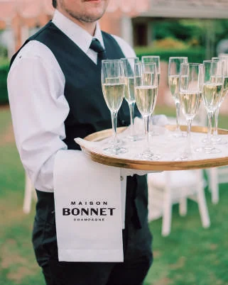 Promotor da Maison Bonnet com bandeja de taças de champagne