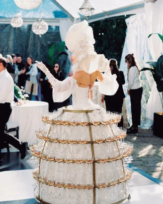 Promotora com vestido Champagne estruturado, com taças dispostas em patamares